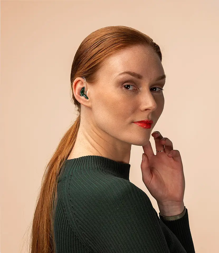 Weibliches Model trägt eine Otoplastik im Ohr.
